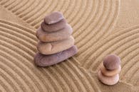 Serene zen stones stacked on raked sand, symbolizing balance and tranquility.